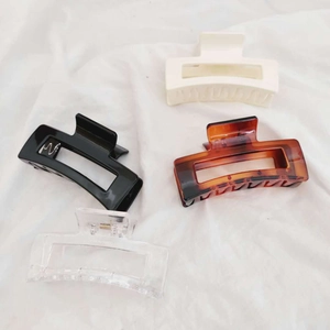Detailed set of four large rectangular claw clips in black, cream, amber, and clear finishes