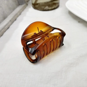 Détail de la pince à cheveux en écaille ambre avec une finition en acétate brillant
