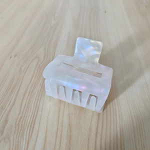 Detail view of square cutout acetate hair claw clip with mother of pearl iridescent finish