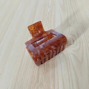 Close-up of square amber tortoiseshell hair claw clip with smooth glossy finish