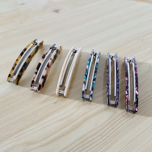 Detail von sechs Acetat-Bananenclips mit Schildpatt- und Marmormustern im Set