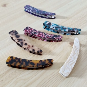 Detail view of acetate tortoise shell banana hair clips in six assorted patterns