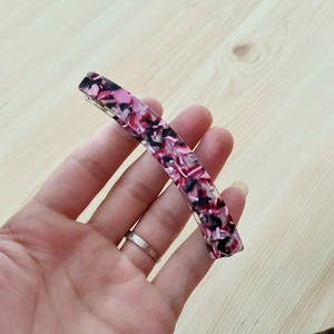 Detail der eleganten rosa Marmor-Acetat-Bananenspange zur Darstellung der Textur