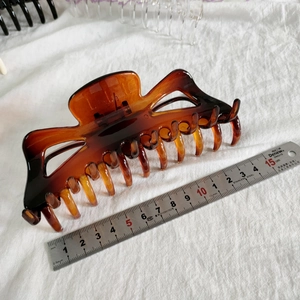 Vue détaillée de la grande pince à cheveux ambre de 13,5 cm avec un ressort métallique