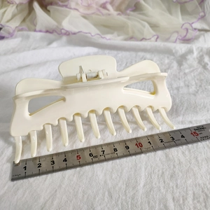 Détail d'une pince à cheveux crème de 13,5 cm avec règle en métal pour les dimensions