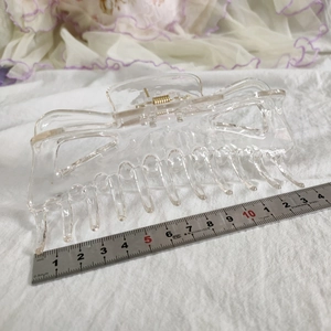 Vue détaillée d'une pince à cheveux transparente de 13cm avec ressort métallique