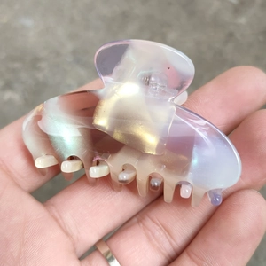 Détail d'une pince à cheveux en acétate irisé aux reflets violets et nacrés élégants