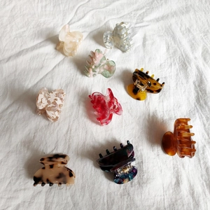 Flat lay of nine colorful acetate hair claw clips with leopard and marble patterns