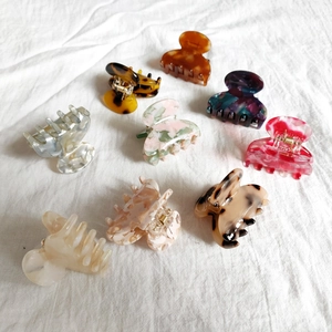Set of 8 mini acetate hair claws with leopard and marble patterns on white linen