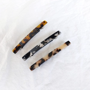 Three acetate spring hair clips in tortoiseshell, marble, and spotted patterns for women