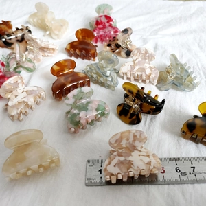 Macro shot of 2-3cm mini acetate hair clips in leopard and marble patterns on white cloth