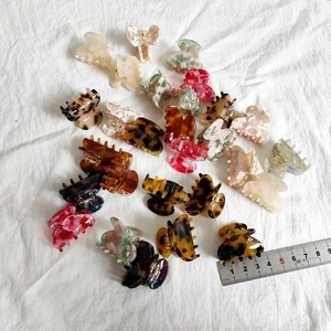Detail view of small acetate hair claws in various patterns with scale for size reference