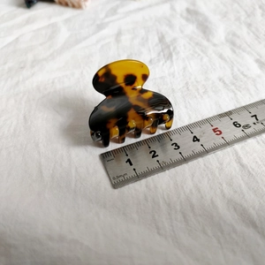 Detail view of a 4cm leopard print acetate hair claw clip with a glossy tortoise finish