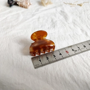 Detail view of 4cm amber tortoiseshell acetate hair claw clip with size ruler measurement