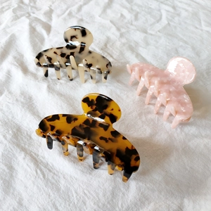 Three elegant French vintage leopard and marble print hair claws on a soft linen fabric