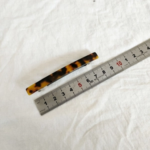 Detail showing an 8.5cm acetate spring hair clip with vintage tortoiseshell patterns