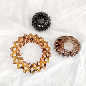 Macro detail of three bird nest expandable hair clips in black and tortoiseshell finishes