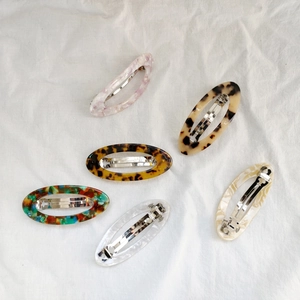 Lot de six barrettes ovales ajourées aux motifs marbre, écaille et fleurs sur lin