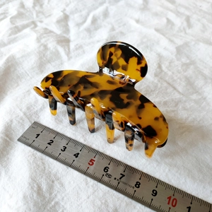 Detail view of a vintage leopard acetate hair claw clip measuring 8.5cm on a ruler