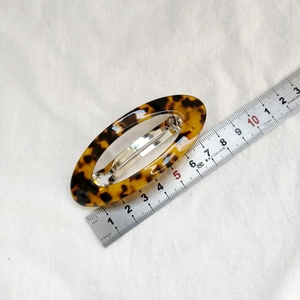 Détail d'une pince à cheveux ovale de 8,5 cm en écaille de tortue avec clip argent