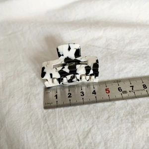 Vue détaillée d'une pince à cheveux en acétate de 5 cm avec motif marbré noir et blanc