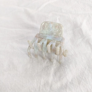 Detailed macro view of the marble texture on this acetate hair claw clip with pearlescent finish