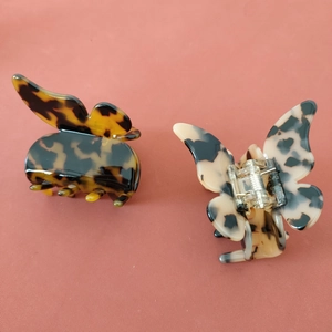 Vue détaillée des pinces à cheveux papillon en acétate avec motifs écailles de tortue variés
