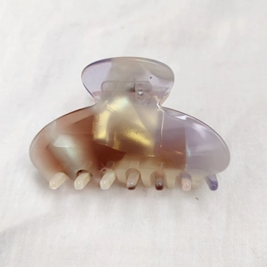 Close-up of a large iridescent acetate hair claw clip with a shimmering mermaid gradient finish