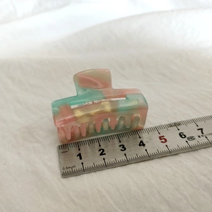 Vue macro d'une pince à cheveux en acétate marbré de 4,5 cm avec règle de mesure