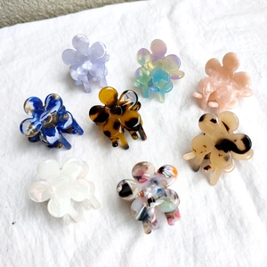 Detailed macro view of 8-piece floral mini hair claw clips in various acetate patterns