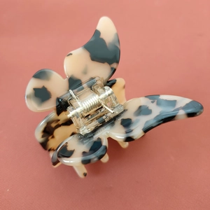 Gros plan détaillé d'une pince à cheveux papillon avec un fini poli écaille de tortue