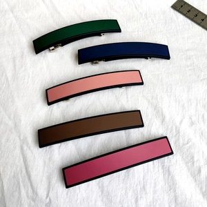 Vue de dessus de cinq barrettes rectangulaires colorées avec pinces à ressort et règle