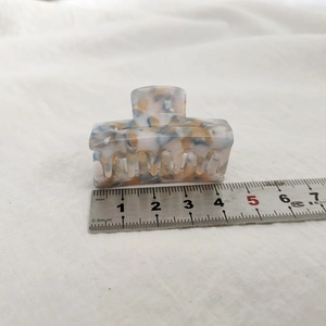 Vue détaillée d'une pince à cheveux en acétate de 4,5 cm avec motif marbré coloré sur tissu