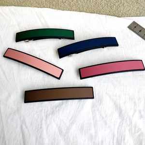 Cinq barrettes à cheveux rectangulaires mates de couleurs assorties sur tissu blanc