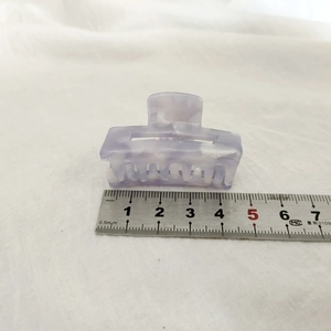 Détail d'une pince à cheveux de 4,5 cm en acétate violet marbré avec règle de mesure