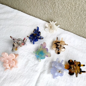 Close-up of assorted mini flower hair clips in various colors and acetate textures