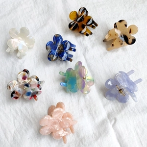 Detailed flat lay of eight small flower hair claws in colorful acetate patterns