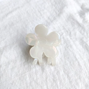 Detailed macro view of small pearl-white flower hair claw clip with a creamy glossy finish