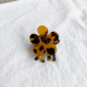 Detail of a floral claw clip with vintage tortoiseshell texture and amber resin finish