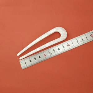 Macro view of a 10.5cm acetate U-shaped hair pin showing elegant white marble texture