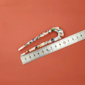Detail view of 10cm acetate U-shaped hair fork with colorful marble pattern
