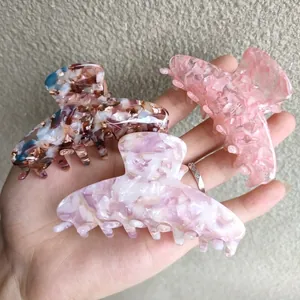 Three acetate hair claws in dark tortoiseshell, lavender, and pink marble patterns