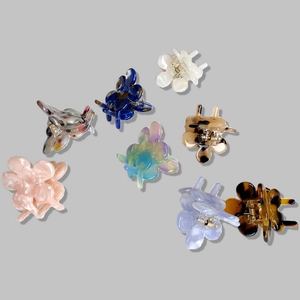 Collection of seven mini floral acetate hair claws in various marble and pearly colors