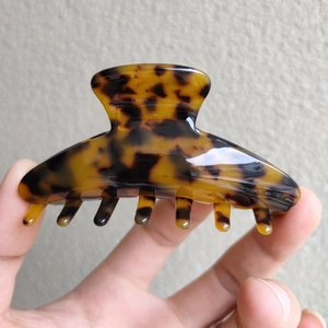 Macro detail of tortoiseshell acetate hair claw clip showing durable teeth and texture