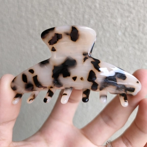 Detail of leopard print acetate hair claw clip with high-gloss finish for women