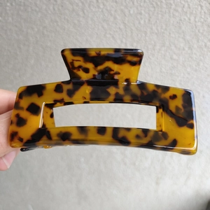 Detailed close-up of a 10cm large leopard print claw clip with a glossy acetate finish