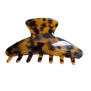Classic tortoise shell hair claw clip with polished amber finish on white background