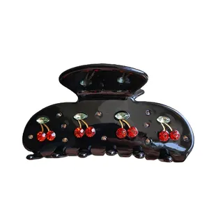 Detail of a black cherry hair claw clip with red rhinestones and crystal accents