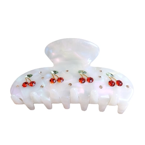 Iridescent white hair claw clip with crystal cherry patterns on a clean white background