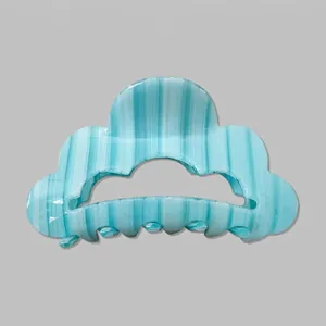 Détail de la pince à cheveux à rayures bleu clair avec bords ondulés et ressort en métal